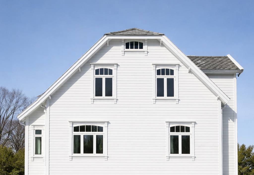 Tradisjonell arkitektur med hvitmalt trefasade og sprossevinduer.