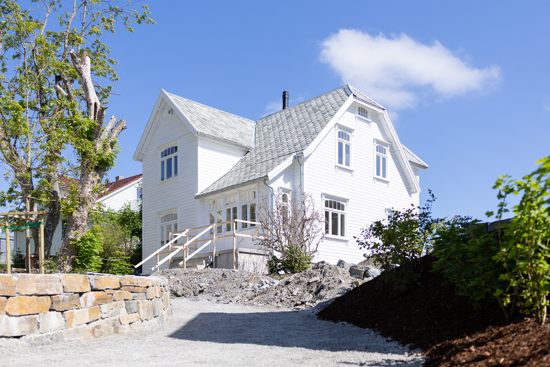 Den restaurerte villaen har fått nytt liv, samtidig som de opprinnelige kvalitetene er ivaretatt. Sett fra grønt-/lekeområdet.