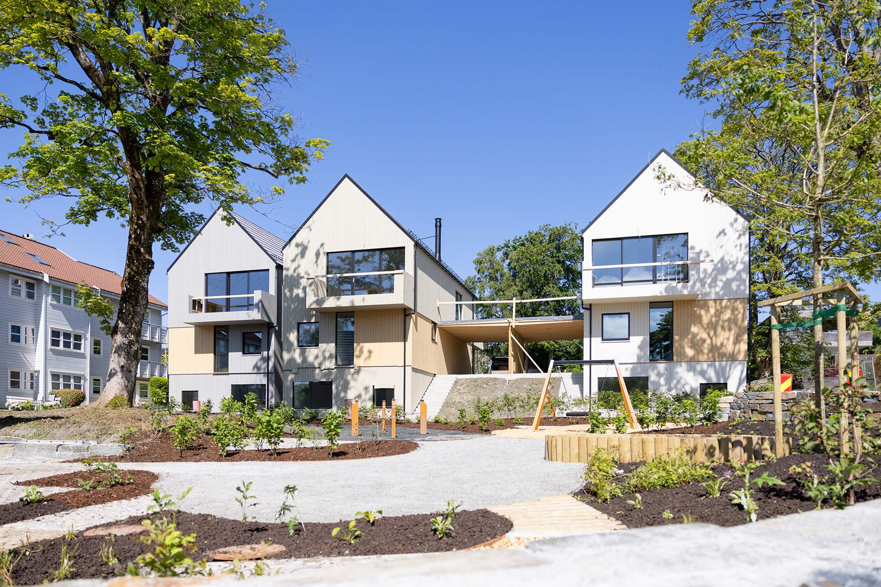 Store vindusflater åpner de moderne byvillaene mot lyset.
